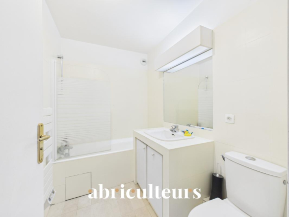 Salle de bain moderne avec baignoire, lavabo et toilettes, dans un duplex à La Celle-Saint-Cloud.