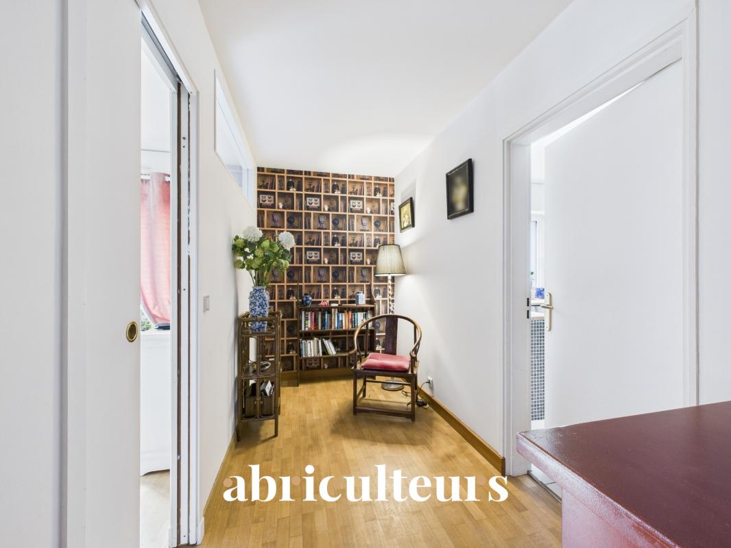 Intérieur d'un duplex familial à La Celle-Saint-Cloud, avec un hall d'entrée lumineux et des murs décorés.
