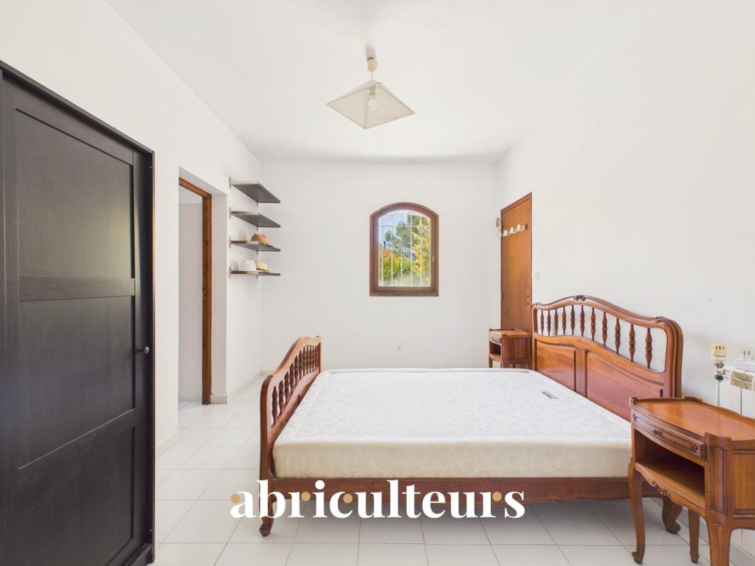 Room of the property in Lambesc Bedroom in a house with a wooden bed and white walls, natural light.