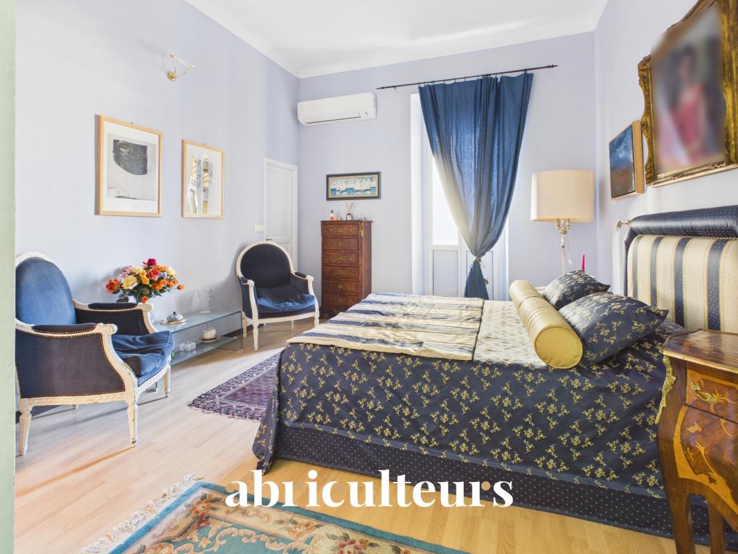 Chambre d’appartement rénové à Nice Chambre d'un appartement rénové avec lit, fauteuils et décorations à Nice.