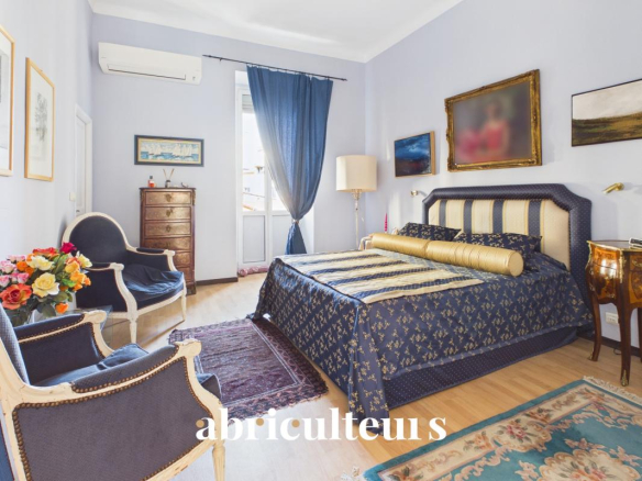Chambre d'un appartement rénové avec lit et mobilier élégant à Nice.