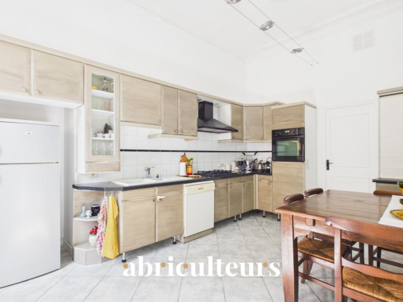 Cuisine moderne et spacieuse d'un appartement rénové à Nice, avec meubles en bois et équipements modernes.