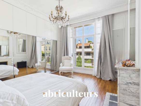 Spacious room with parquet flooring and large windows in an old apartment in Saint-Mandé.
