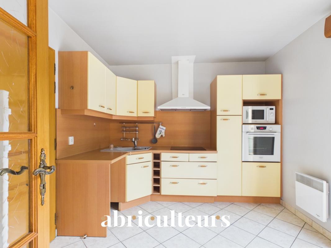 Kitchen in a house in Versailles Modern and functional kitchen in a family home in Versailles, with light wood furniture and integrated appliances.