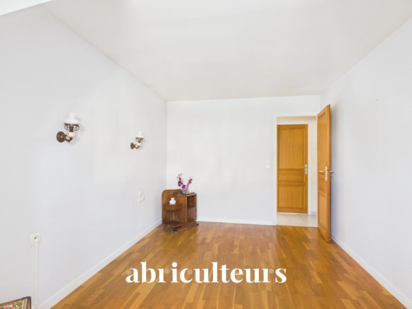 Intérieur d'une maison familiale avec un sol en parquet et des murs clairs.