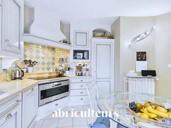 Cuisine moderne et lumineuse d'une villa à Cheval-Blanc avec table en verre et fruits.
