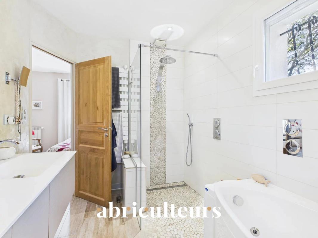 Salle de bain d’une villa rénovée à Cheval-Blanc Salle de bain moderne avec douche et baignoire dans une villa rénovée.