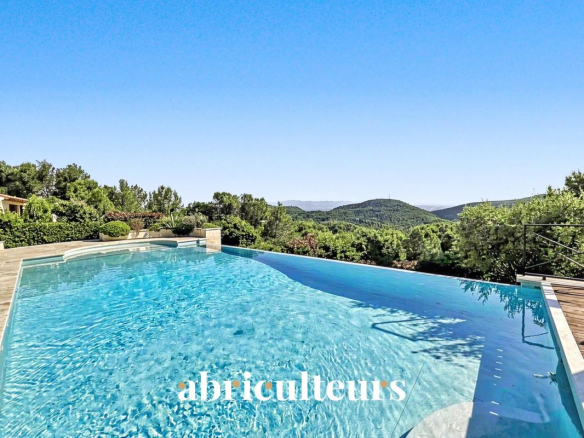 Vue de la piscine à débordement avec paysage verdoyant en arrière-plan à Rognes.