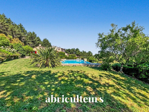 Vue d'une villa avec piscine et jardin à Rognes, entourée d'arbres.