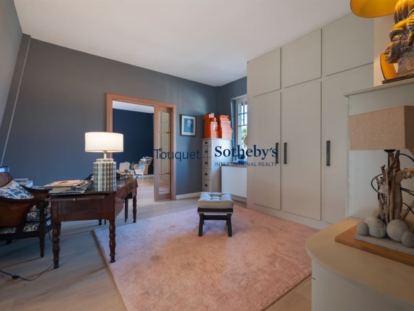 Intérieur d'une villa élégante avec un espace de travail et un tapis clair.