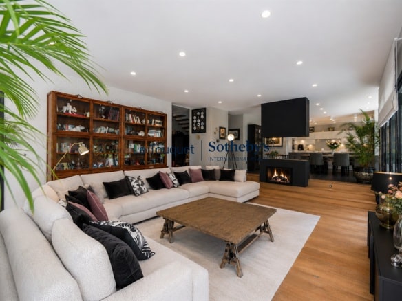Interior of a contemporary villa with a spacious and bright living room, modern furniture and fireplace.