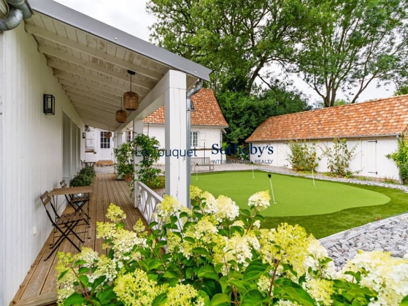 Gîte avec putting-green et terrasse à Montreuil, entouré de fleurs et d'un jardin calme.