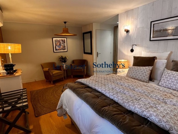 Chambre décorée avec lit double et mobilier en bois dans un gîte à Montreuil.