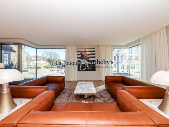 Interior of a modern architect-designed villa with leather sofas and large windows.