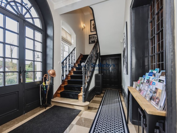 Interior of an 18th-century manor house with an entrance hall and a wooden staircase.