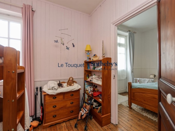 Chambre d'enfant dans une villa au Le Touquet-Paris-Plage, avec meubles en bois et jouets.