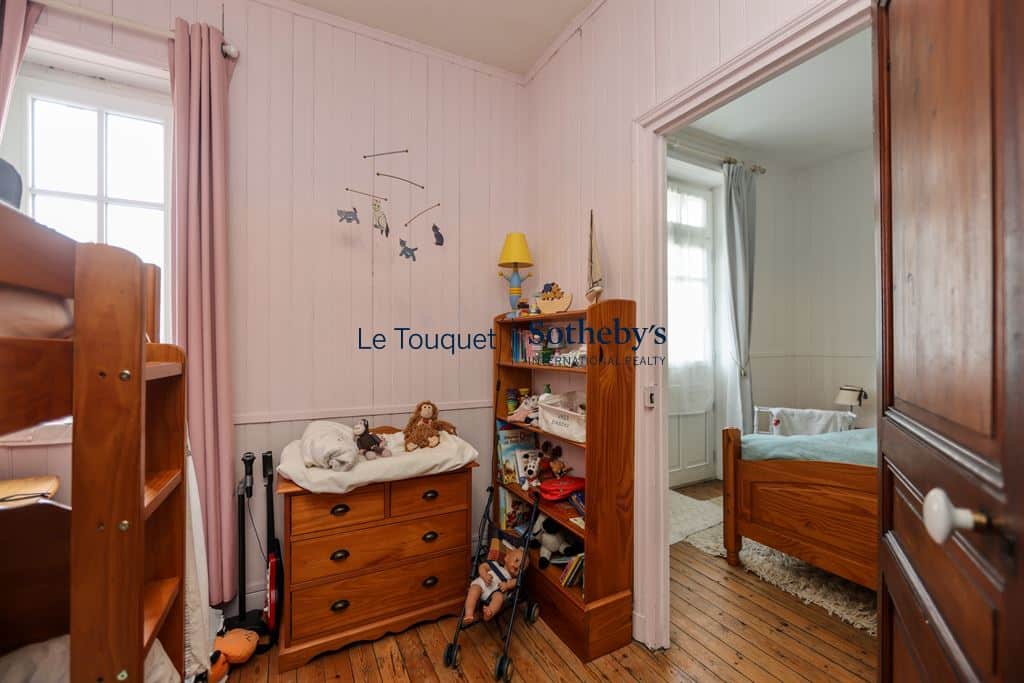 Chambre d'enfant dans une villa au Le Touquet-Paris-Plage, avec meubles en bois et jouets.