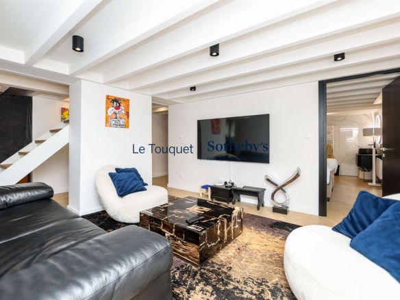 Interior of a contemporary duplex with living room, television and staircase.
