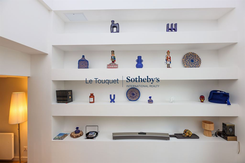 Decorative shelf in a contemporary duplex with art and design objects.