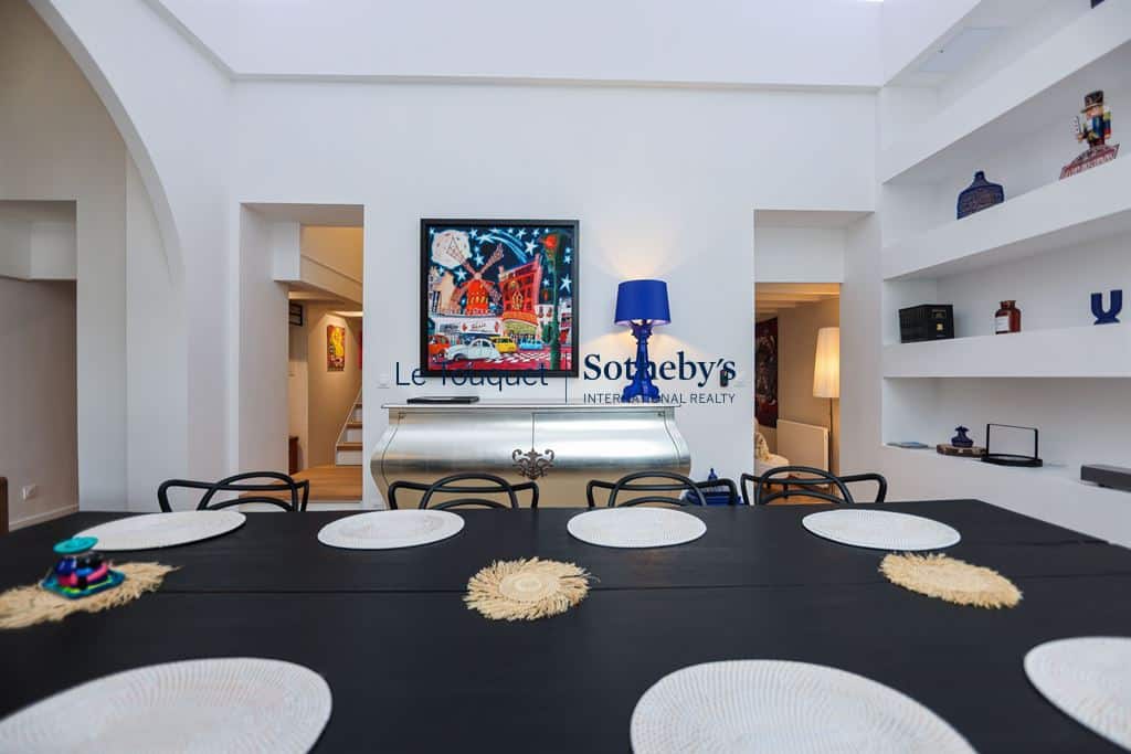 Interior of a contemporary duplex in Le Touquet, with a large table and a high ceiling.