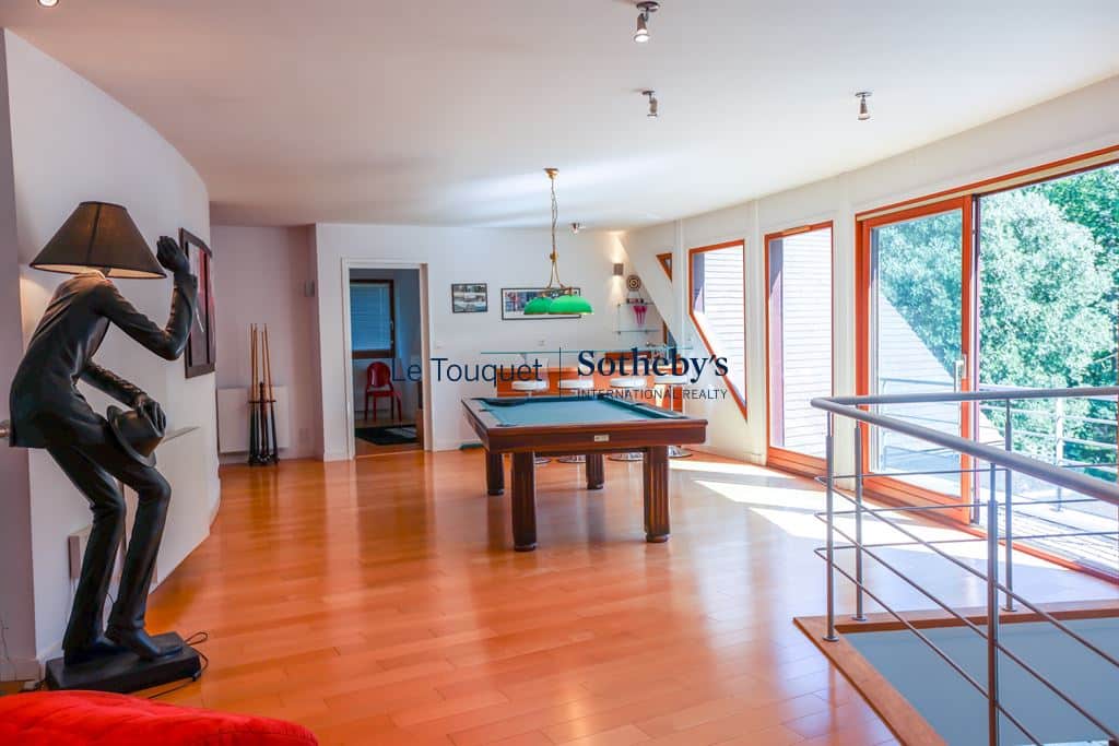 Interior of a contemporary villa with living room, billiards and large windows, Le Touquet-Paris-Plage.