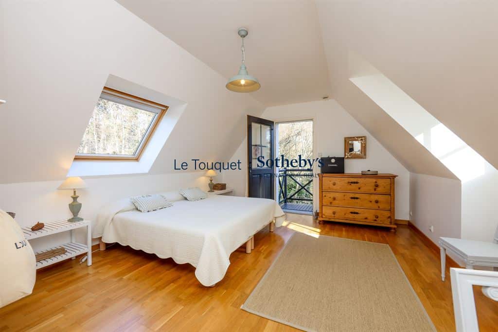 Bright room with a double bed, wooden furniture and access to a balcony.