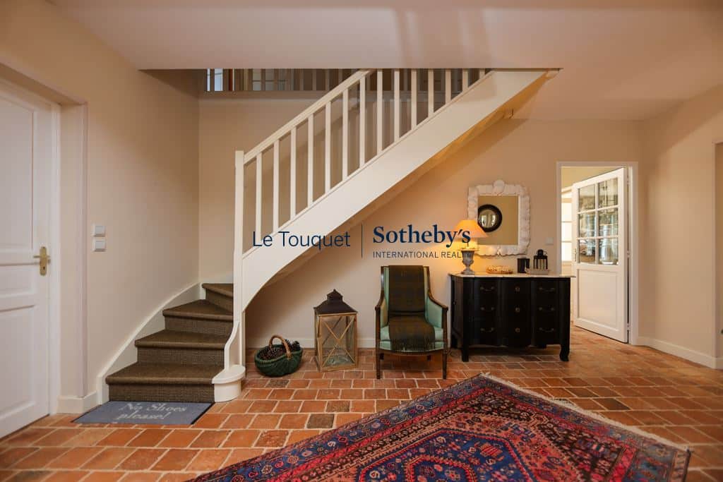Interior of a Flemish longhouse in Hardelot, with entrance hall, staircase and refined decoration.