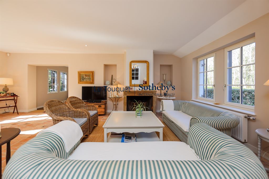 Interior of a Flemish longhouse in Hardelot, with a bright living room and fireplace.