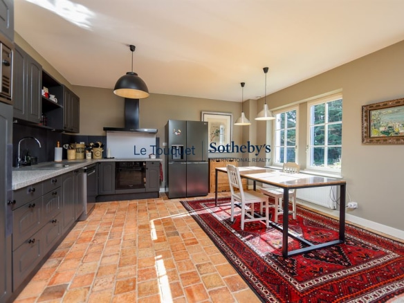 Kitchen of a Flemish longhouse in Hardelot, with modern furniture and rug.