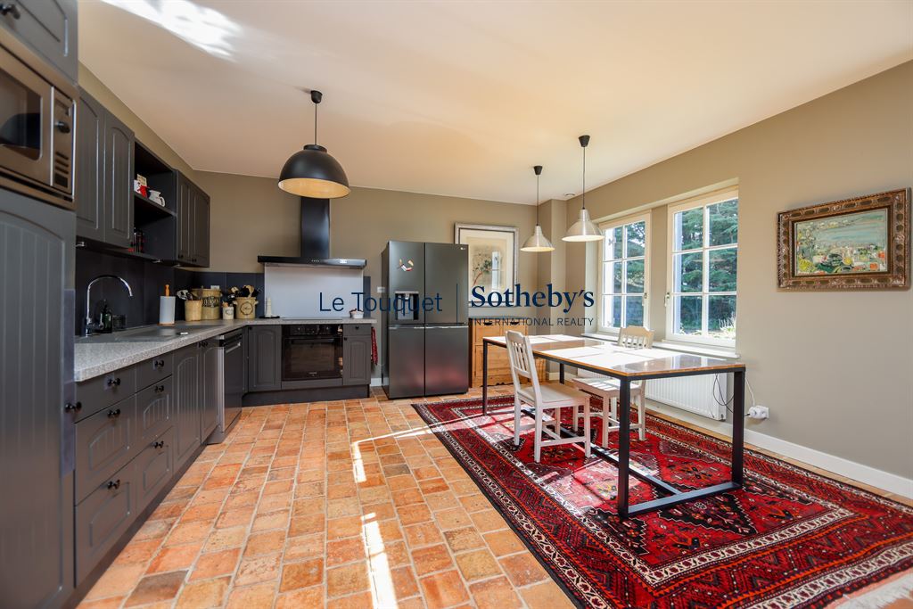 Kitchen of a Flemish longhouse in Hardelot, with modern furniture and rug.