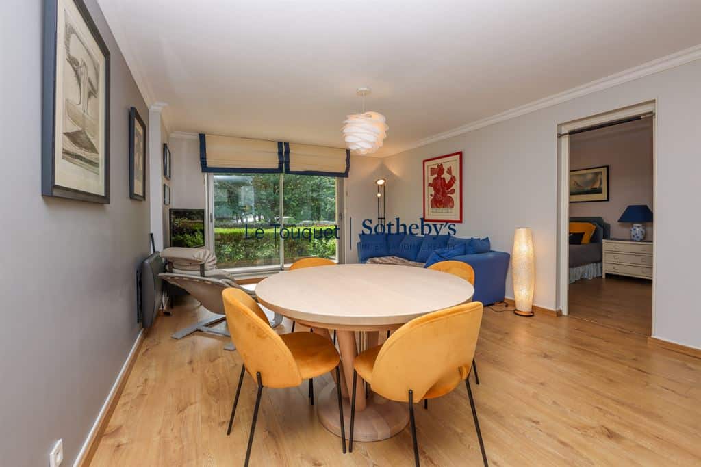 Interior of a 77 m² apartment with living room, dining room and access to the outside.