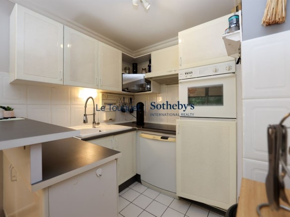 Equipped kitchen in a 77 m² apartment in Le Touquet-Paris-Plage, with light-colored furniture and appliances.