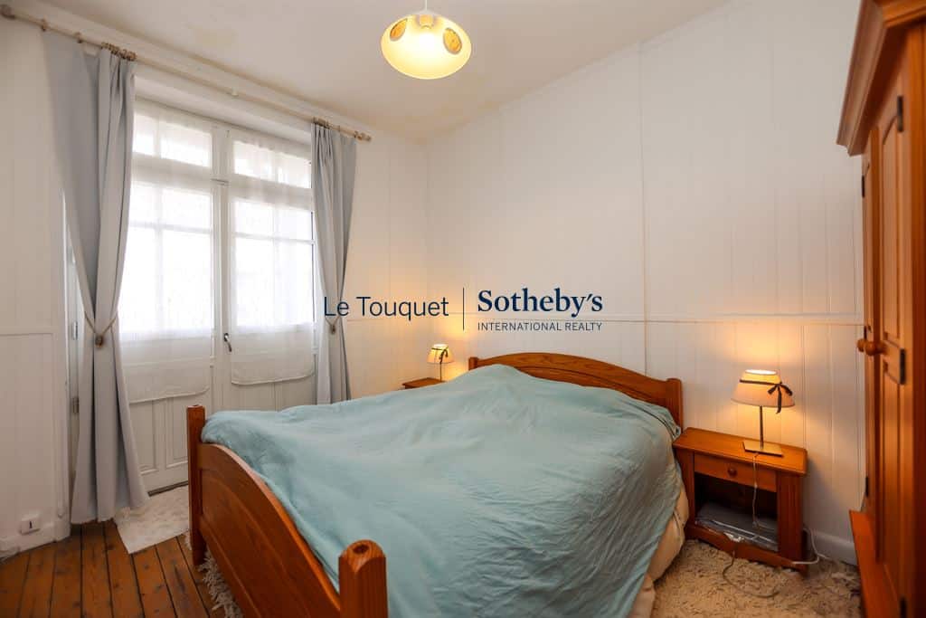 Room in a villa in Le Touquet-Paris-Plage with a wooden bed and bright decor.