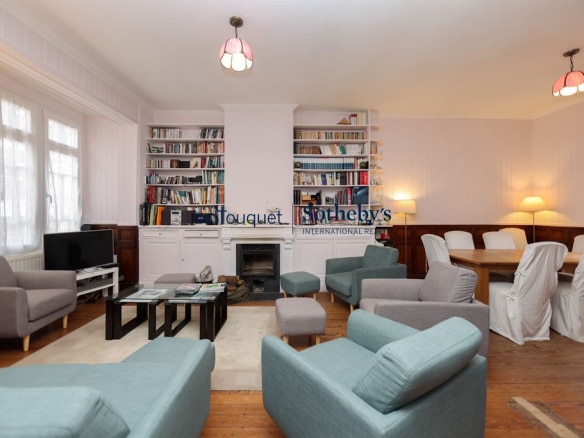 Interior of a villa in Le Touquet with bright living room, fireplace and library.