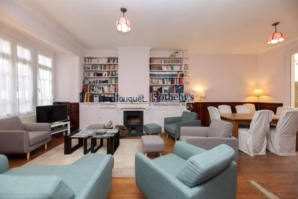 Interior of a villa in Le Touquet with bright living room, fireplace and library.