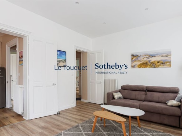 Living room of a renovated apartment with sofa and modern decor in Le Touquet-Paris-Plage.