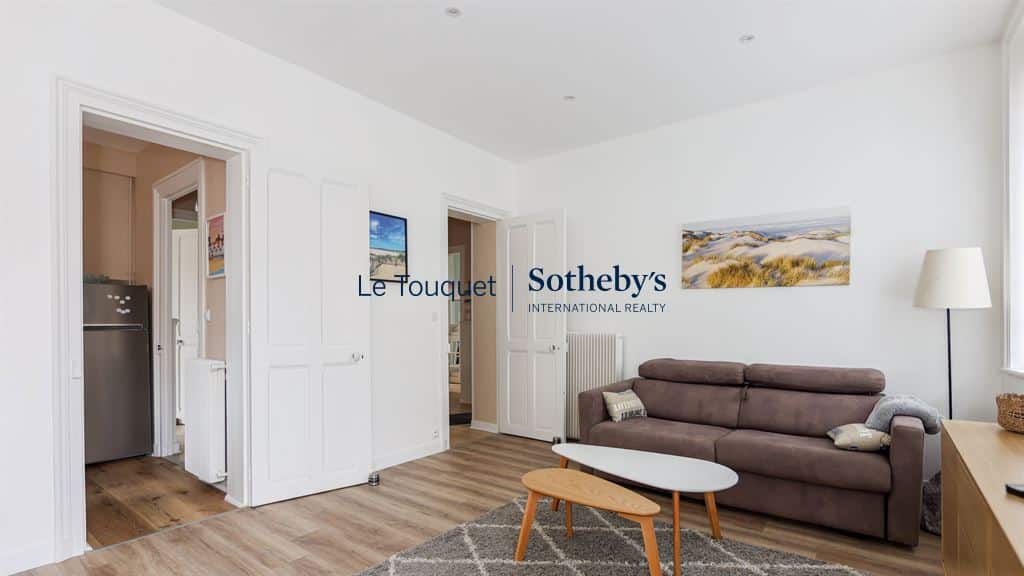Living room of a renovated apartment with sofa and modern decor in Le Touquet-Paris-Plage.