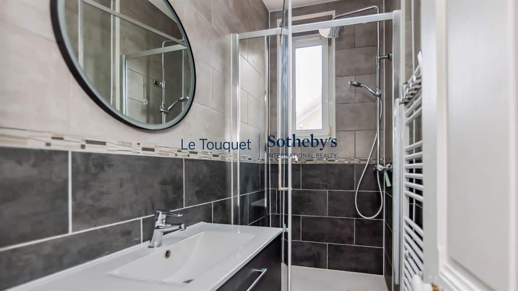 Modern bathroom with shower and sink in a renovated apartment in Le Touquet-Paris-Plage.