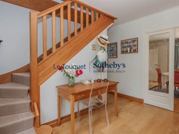 Interior of a family villa with a wooden staircase and a bright entrance hall.