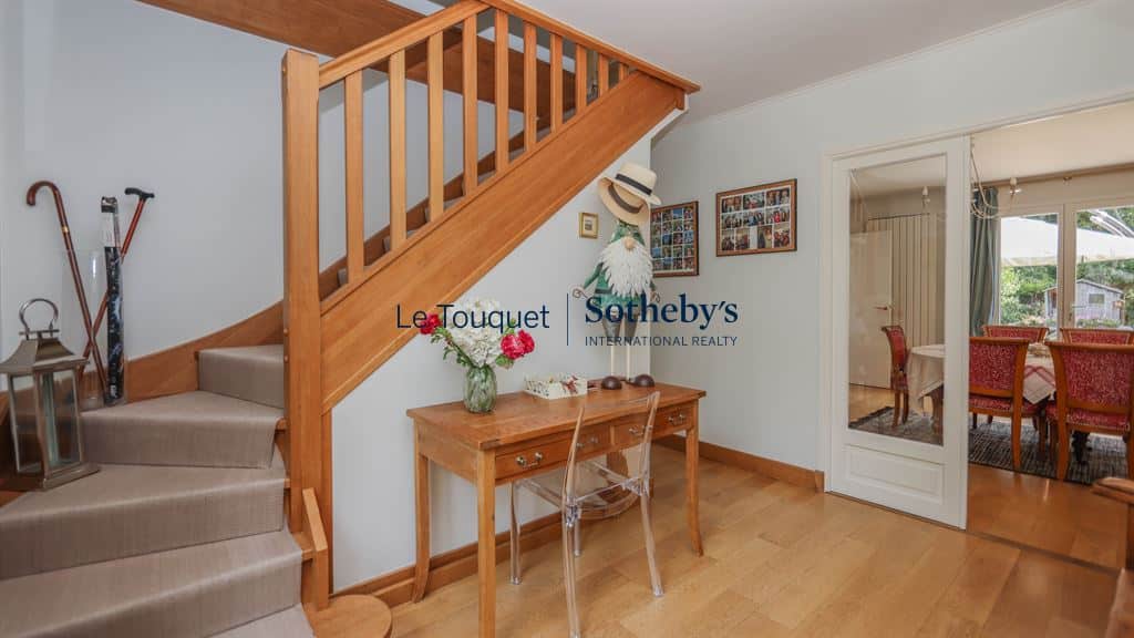 Interior of a family villa with a wooden staircase and a bright entrance hall.