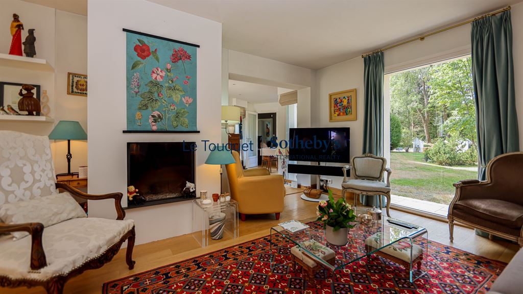 Interior of an elegant family villa with a bright living room and access to a garden.