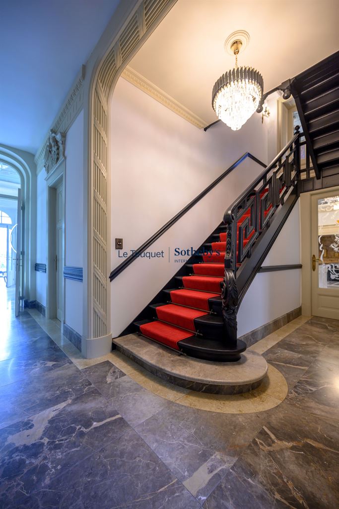Escalier d’un hôtel particulier Escalier avec rampe en fer forgé et moquette rouge dans un hôtel particulier du XIXème siècle à Mérignies.