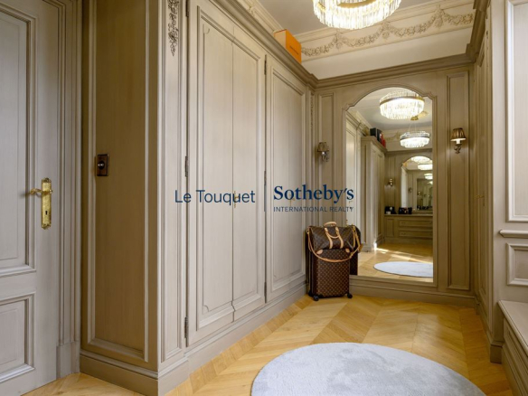 Intérieur d'un hall d'entrée élégant avec boiseries et miroir, éclairage sophistiqué.