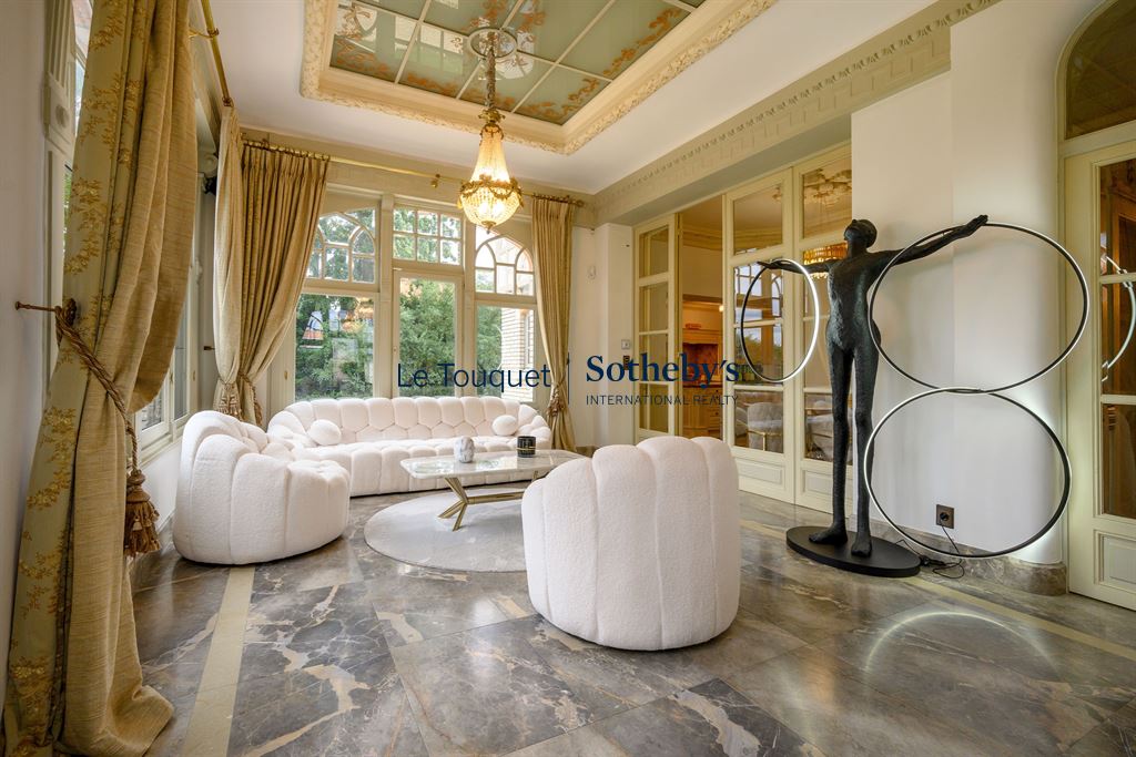 Salon d’un hôtel particulier du XIXème à Mérignies Intérieur d'un salon élégant avec canapé blanc, sculpture moderne et grandes fenêtres.