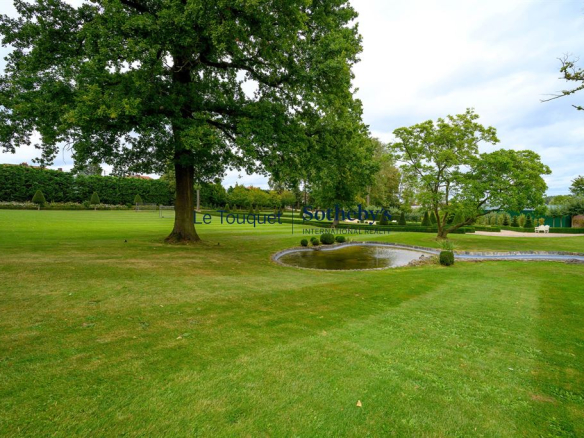 Parc paysagé avec bassin et arbres au sein d'un hôtel particulier du XIXème à Mérignies.