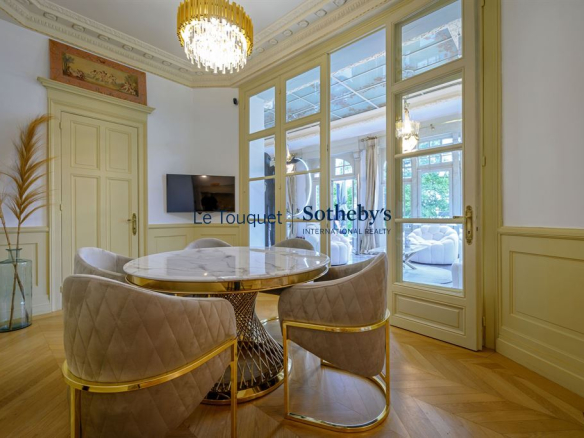 Intérieur d'un hôtel particulier du XIXème avec une salle à manger élégante et des fauteuils modernes.