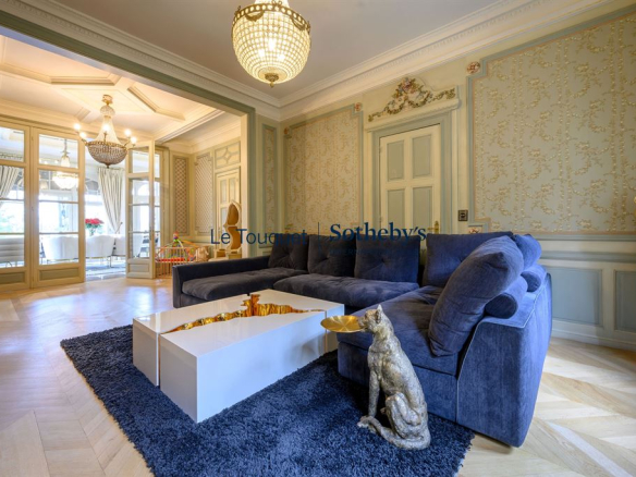 Intérieur d'un salon d'un hôtel particulier du XIXème siècle avec canapé, table basse et décoration élégante.