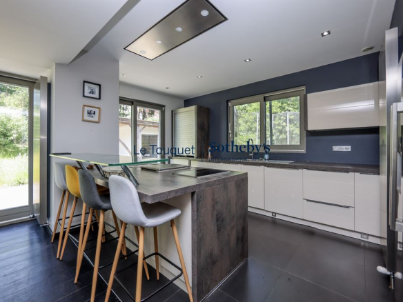 Modern kitchen in a contemporary villa with bar and access to the garden.