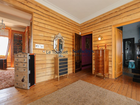 Intérieur d'une villa balnéaire avec murs en bois et meubles anciens.