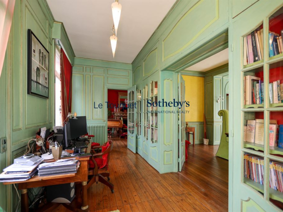 Intérieur d'une villa balnéaire à Wimereux avec des murs verts et un mobilier ancien.